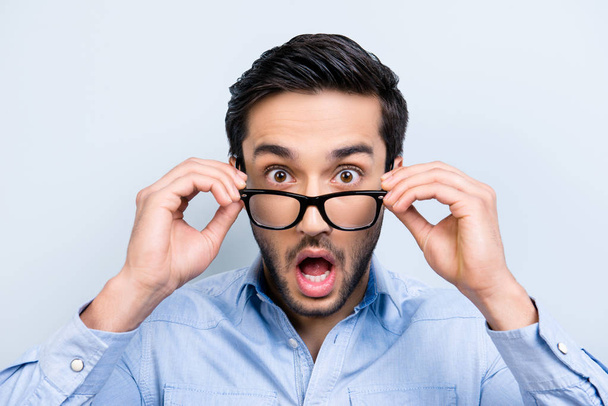 OMG! WTF! Head shot of shocke  funny guy with black hair wide open mouth big-eyed looking out glasses on face isolated on grey background - Fotoğraf, Görsel