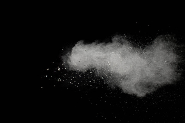 Bizarre forms of  white powder explosion cloud against dark background. Launched white particle splash on black background - Photo, Image