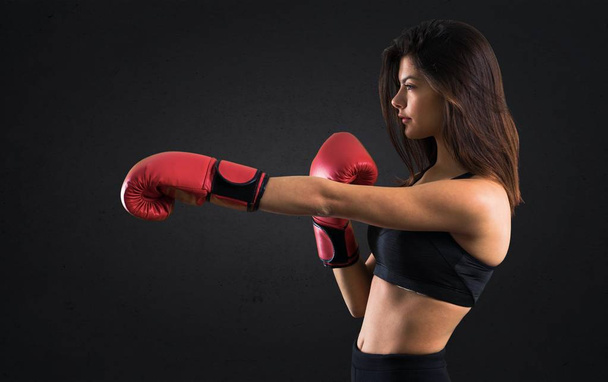 Nuori urheilu tyttö nyrkkeily käsineet musta tausta
 - Valokuva, kuva