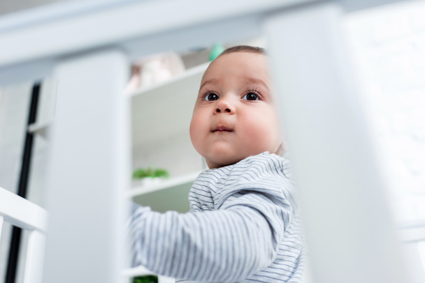 close-up portrait of adorable little child in baby cot - 写真・画像