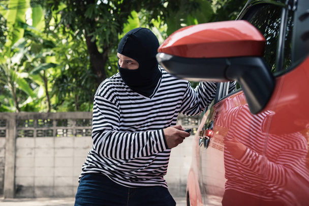 Araba hırsızı erişmek için çalışır ve bir araba uzaktan kumanda ile kilidini. - Fotoğraf, Görsel
