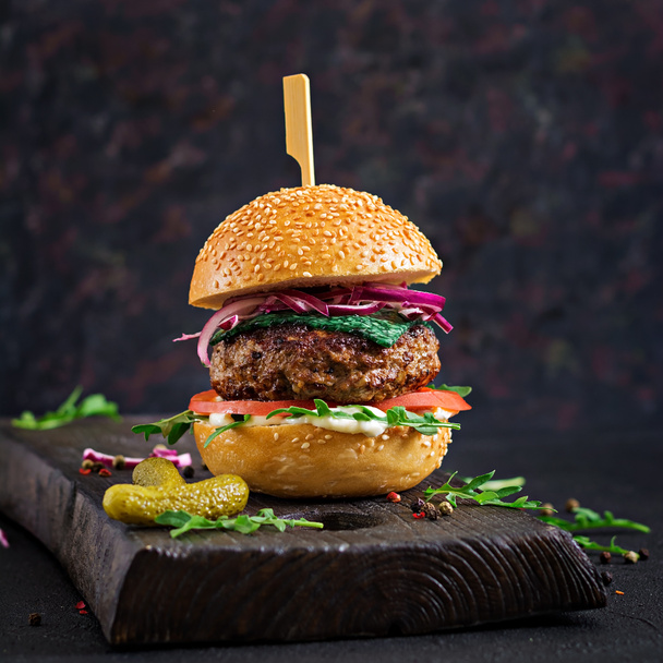 Великий бутерброд бургер з яловичиною, помідорами, базиліковим сиром та руколою
. - Фото, зображення