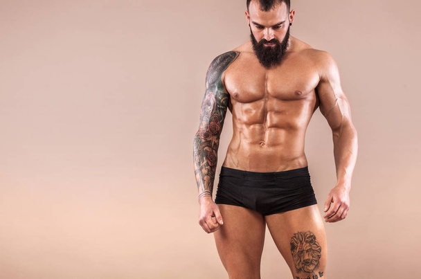 Muscular young fitness sports man with strong fit body on light background. - Fotó, kép