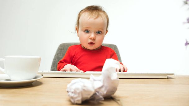 Boldog gyermek baba lány kisgyermek ül a billentyűzet számítógép elszigetelt fehér background - Fotó, kép
