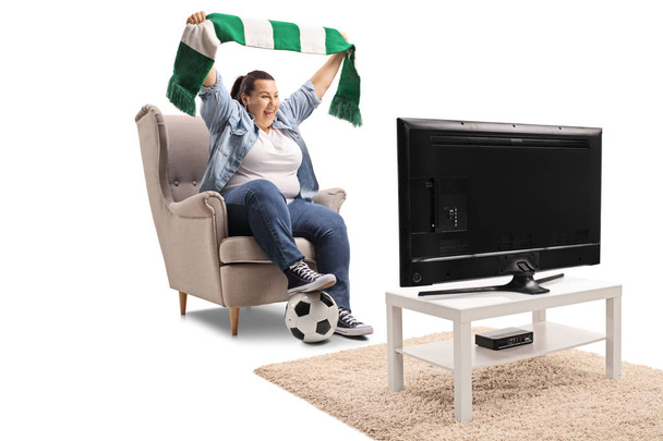 Excited female soccer fan holding a scarf and watching a match on television isolated on white background - Φωτογραφία, εικόνα