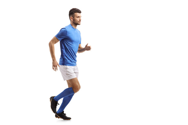 Full length profile shot of a soccer player running isolated on white background - 写真・画像