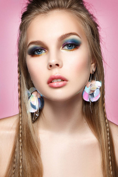Beautiful woman portrait with colorful make up and bright earrings. - 写真・画像