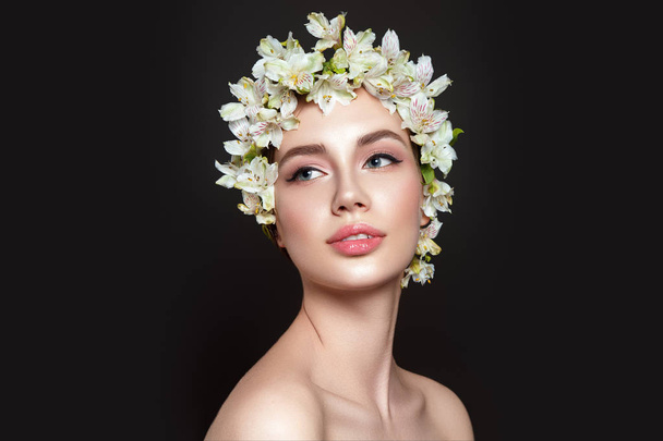 Beautiful woman portrait on black background with flowers on head. - Zdjęcie, obraz