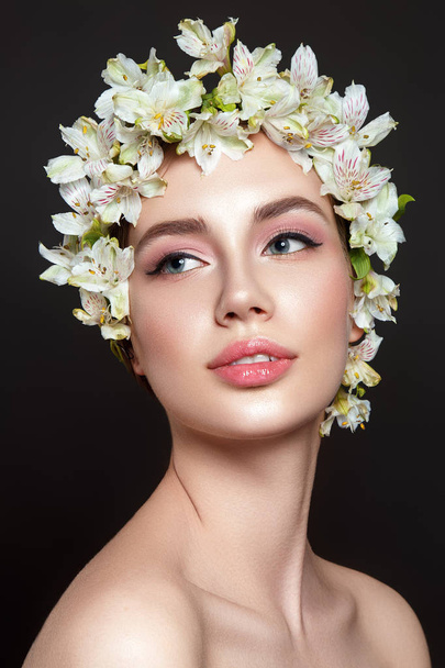 Beautiful woman portrait on black background with flowers on head. - Foto, afbeelding