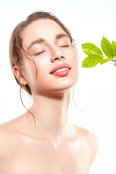 Beautiful woman portrait with fresh wet skin and green plant. - Foto, Imagen
