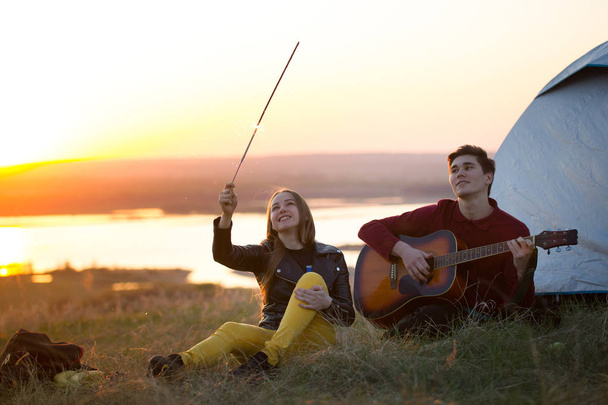 Jovem casal feliz se divertindo juntos tocando guitarra no hil
 - Foto, Imagem
