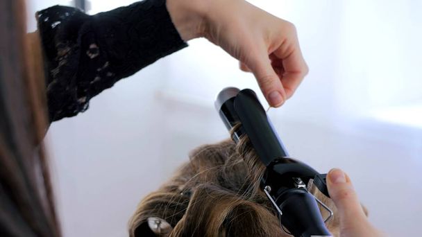 Profesjonalny salon fryzjerski robi fryzurę dla kobiety - Dokonywanie loki - Zdjęcie, obraz