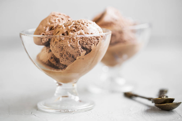 Mπάλες παγωτό σοκολάτα σε γυάλινα φλυτζάνια μισό λιωμένο. Νόστιμο δροσιστικό καλοκαιρινό γλυκάκι  - Φωτογραφία, εικόνα