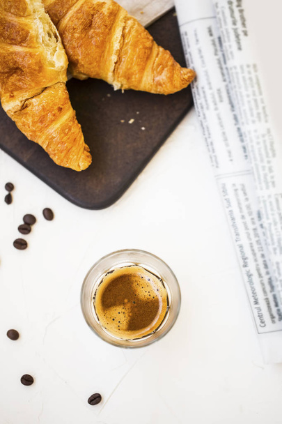 Espresso kahvi lasi croissants ja sanomalehti. Aamukahvi
 - Valokuva, kuva