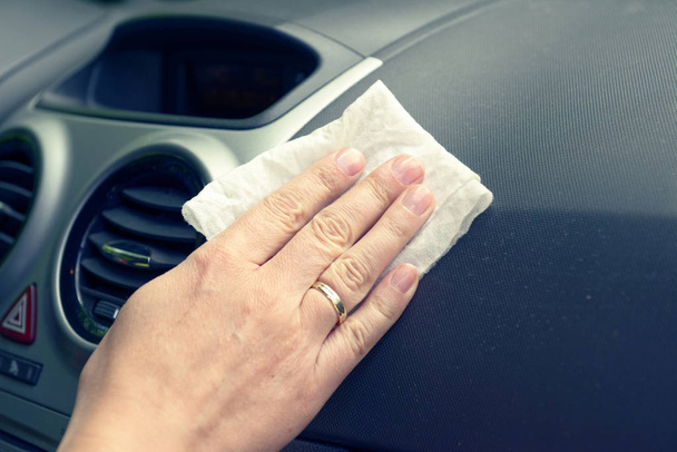 Hand with white cloth cleaning modern car interior - Photo, Image