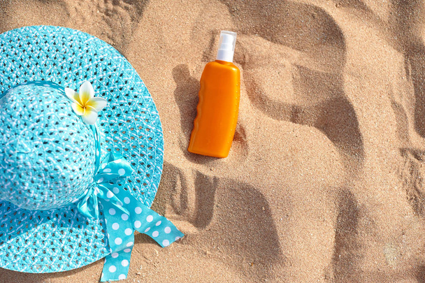 солнцезащитный крем, шляпа на песке, концепция летних каникул, оптика с местом для текста
 - Фото, изображение