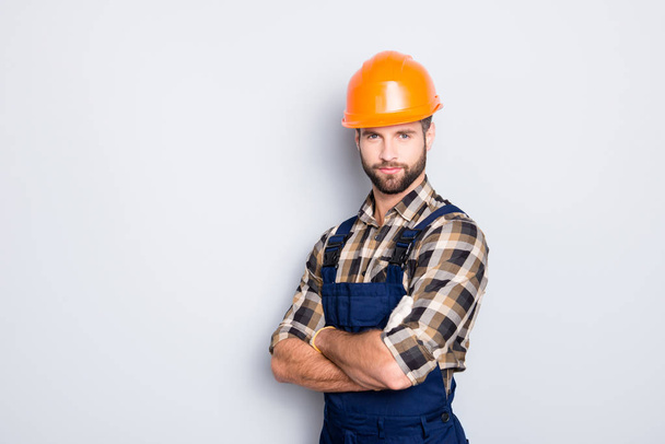 Portrait with copyspace of attractive handsome repairer in shirt and overall looking at camera isolated on grey background, having arms crossed, isolated on grey background - Foto, imagen