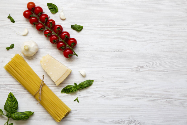 Verschillende ingrediënten voor het koken van pasta op een witte houten achtergrond, van bovenaf. Flat lag. Bovenaanzicht. Kopiëren van ruimte. - Foto, afbeelding