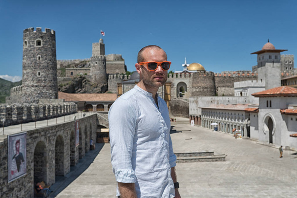 Man model with sunglasses and white shirt in old Georgian castle - Foto, Imagen