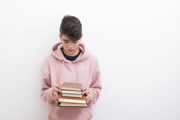 εφηβική μαθητής με βιβλία στον λευκό τοίχο - Φωτογραφία, εικόνα