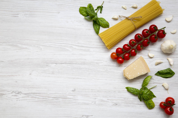 Ingredientes diferentes para cozinhar macarrão italiano em um fundo de madeira branca, vista superior. Deitado. Espaço de cópia
. - Foto, Imagem