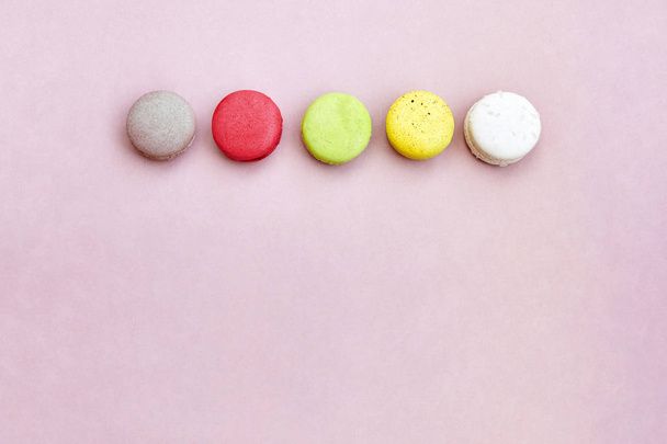 A group of colorful french dessert macaroons or macarons on the lemonade color background with space for text, top view, isolated - Photo, image