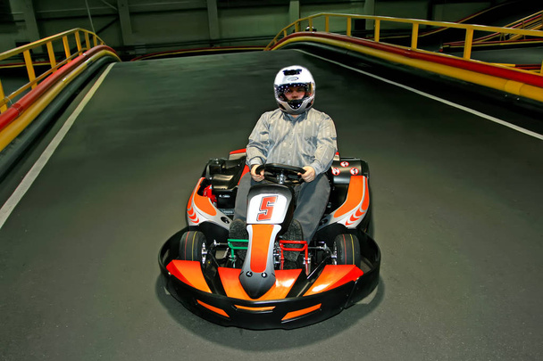 un hombre con casco en el karting en la pista de karting en el interior
 - Foto, imagen