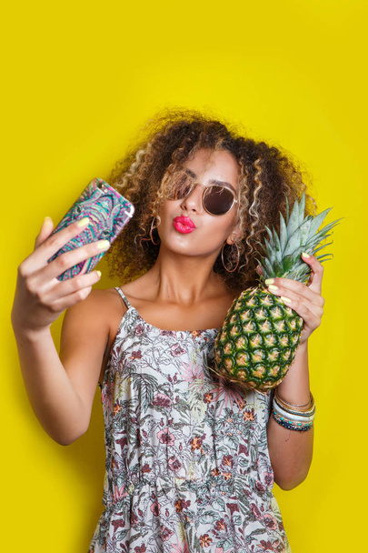 Beautiful Girl selfie with a smartphone. Beautiful young African American woman with afro hairstyle - Zdjęcie, obraz