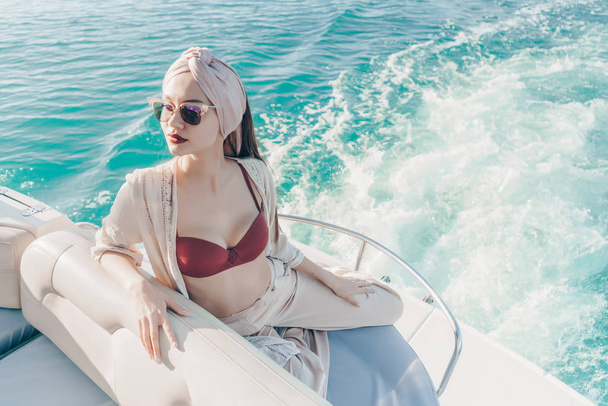 a luxurious attractive girl in sunglasses enjoys a rich life, sails on the Caribbean sea - Фото, изображение