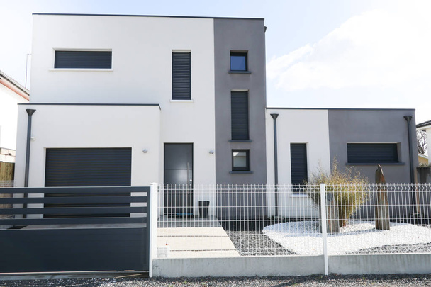 wit grijs huis buitenkant met deur en garage - Foto, afbeelding
