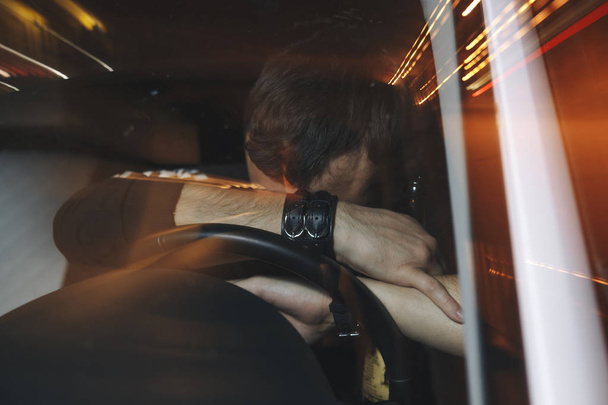 Autista maschio sconvolto viene catturato alla guida sotto l'influenza di alcol. Uomo che si copre il volto dalla luce della macchina della polizia
. - Foto, immagini
