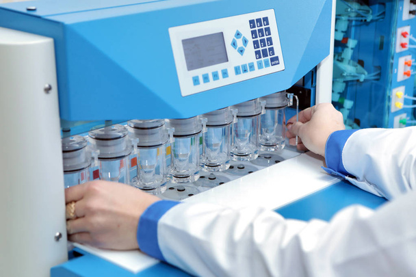 Obtaining precise results of analyzes of difficult soluble drugs. The girl is doing tests in pharmaceuticals. Sotax Ag. Production and analysis of tablets. Modern pharmaceuticals. Factory producing tablets. Laboratory of quality. - Photo, Image