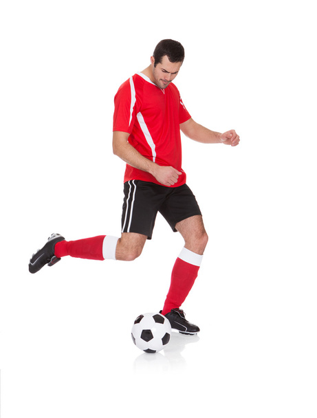 Professional soccer player kicking ball - Foto, afbeelding