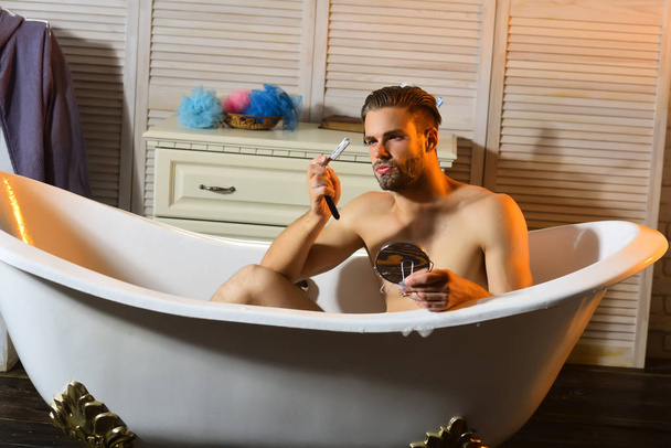 Bearded young man holding retro shaving tools in hands - Photo, Image
