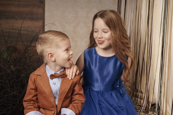 μικρό χαριτωμένο αγόρι κορίτσι αγκαλιάζει παίζοντας σε λευκό φόντο, ευτυχισμένη οικογένεια από κοντά απομονωμένη. αδερφός και αδελφή χαμογελούν - Φωτογραφία, εικόνα