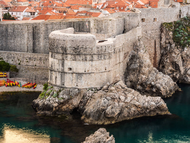 Casas y edificios con techos de teja de arcilla roja construidos en la ladera de Dubrovnik Croacia con muros históricos de mampostería que rodean el casco antiguo
. - Foto, imagen