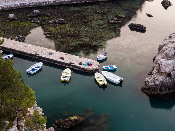 Nézett le egy pár kis motorcsónakok kötve a végén a falazott vagy beton mólón vagy dokkoló le az Adriai-tenger-öböl egy nyugodt reggel Dubrovnik Horvátország hal hálók közeli megállapításáról. - Fotó, kép