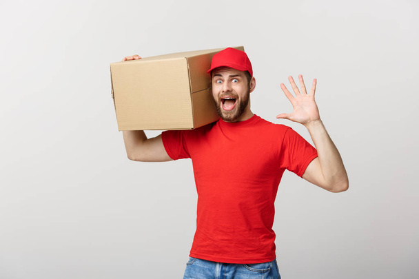 Delivery man doing surprise gesture holding cardboard boxes. - 写真・画像