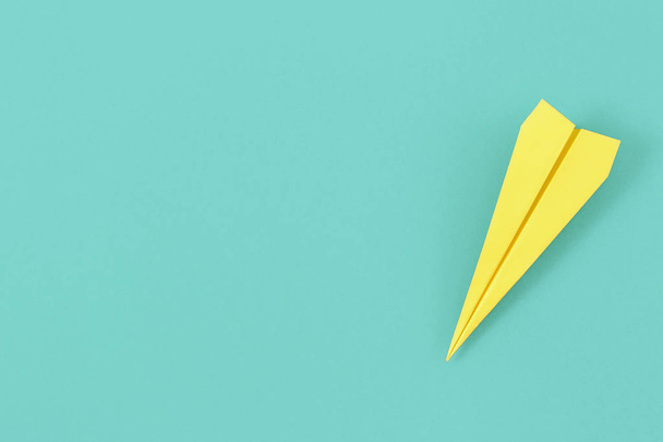 Flat lay yellow paper plane on pastel blue background with copy space. Top view creative travel background concept - Fotoğraf, Görsel