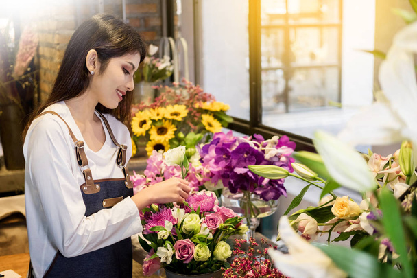 junge Geschäftsinhaberin Floristin macht Blumenstrauß vor Blumenladen - Foto, Bild