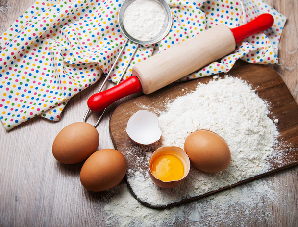 Składniki do pieczenia - mąkę z jajkami i wałek do ciasta - Zdjęcie, obraz