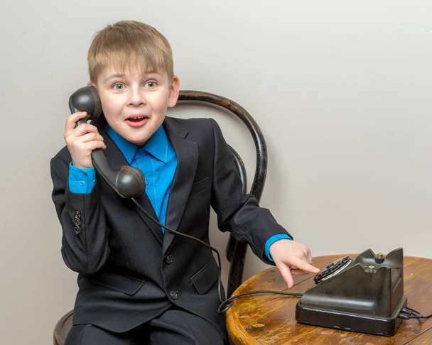 The little boy is ringing the old telephone. - Φωτογραφία, εικόνα