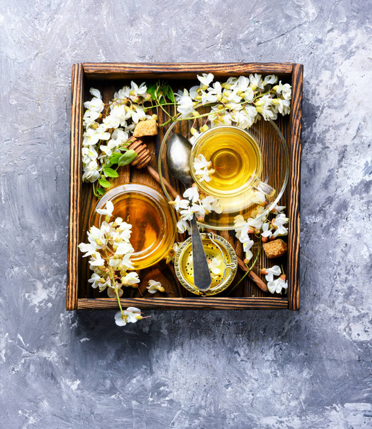 Curación de té de hierbas con miel de flores de acacia.
 - Foto, Imagen