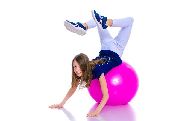 little girl doing exercises on a big ball for fitness. - Foto, immagini