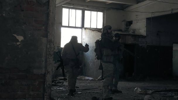 Soldiers in camouflage with combat weapons sneak along the corridors of the old building, the military concept - Foto, Imagem