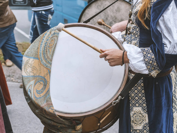 Actor plays musical instrument drum during medieval festival - Foto, imagen
