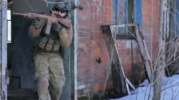 Soldaten in camouflage met bestrijding wapens maken hun weg naar buiten het oude gebouw, met het doel van het vangen, het militaire concept - Video