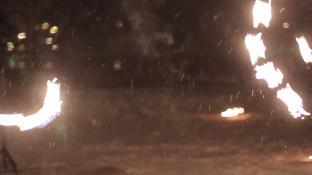 Úžasné taneční show rodového ohně v noci v zimě pod padajícím sněhem. Taneční skupina provádí s pochodeň světla a pyrotechniky na zasněžené počasí. - Záběry, video
