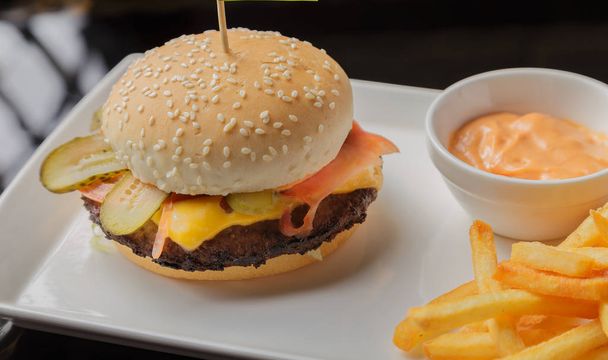 Burger egy tányérra, sült burgonyával és a mártással - Fotó, kép