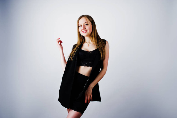Girl model in black wear posed at studio on white background.  - Foto, afbeelding